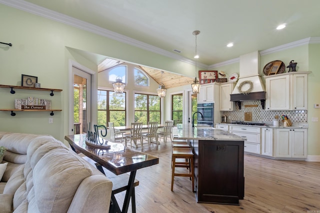 13518 Pikes Peak Pl, Rogers, AR 72756 - kitchen with open floor plan, cooktop, stainless steel double oven, lofted ceiling, and a kitchen bar
