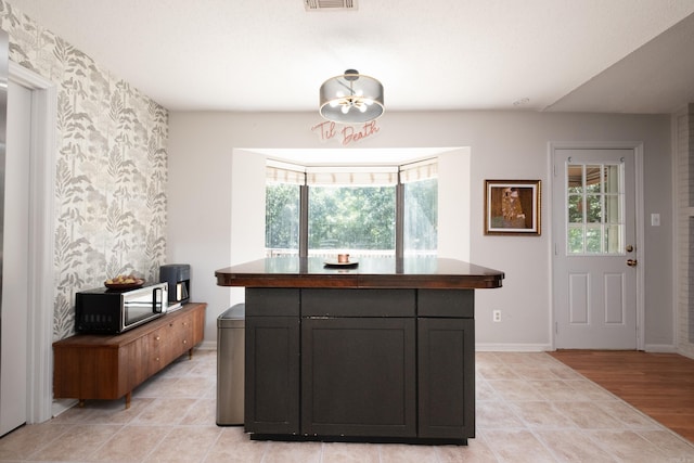 kitchen featuring stainless steel microwave and baseboards