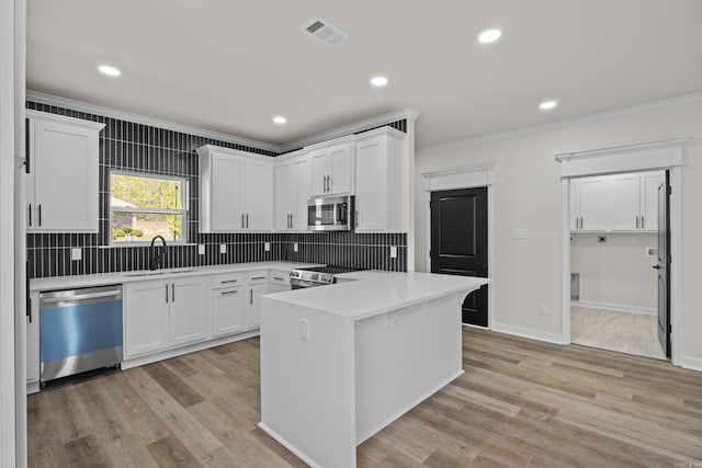 7213 Stonehenge Dr, Sherwood, AR 72120 - kitchen with appliances with stainless steel finishes, ornamental molding, white cabinetry, decorative backsplash, and recessed lighting
