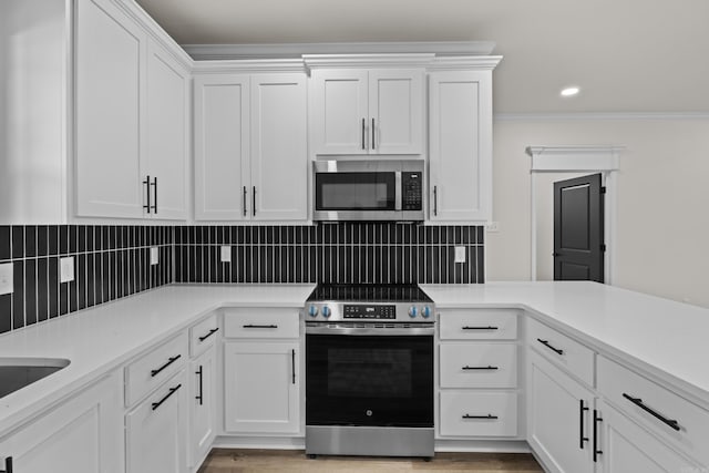 7213 Stonehenge Dr, Sherwood, AR 72120 - kitchen featuring appliances with stainless steel finishes, white cabinets, light countertops, crown molding, and recessed lighting