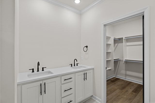 7213 Stonehenge Dr, Sherwood, AR 72120 - bathroom featuring crown molding, wood finished floors, double vanity, a walk in closet, and recessed lighting