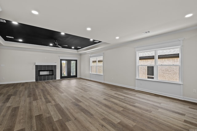 7213 Stonehenge Dr, Sherwood, AR 72120 - unfurnished living room with a raised ceiling, ceiling fan, wood finished floors, a fireplace, and ornamental molding