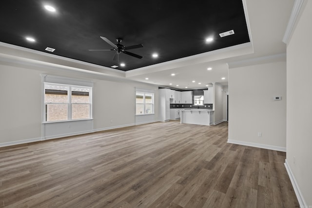 7213 Stonehenge Dr, Sherwood, AR 72120 - unfurnished living room with a tray ceiling, ornamental molding, ceiling fan, light wood-style floors, and recessed lighting