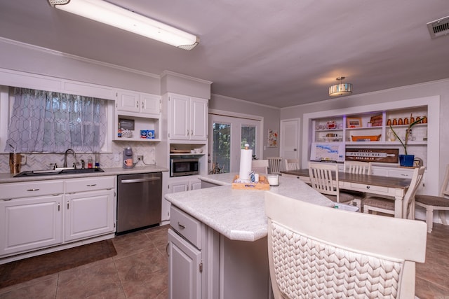 4203 Glenda Ln, Benton, AR 72019 - kitchen with appliances with stainless steel finishes, light countertops, backsplash, a kitchen island, and white cabinetry