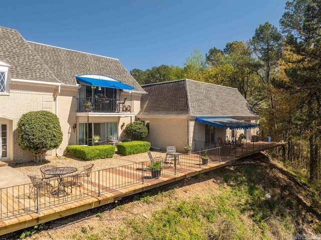 501 Belvedere Unit C-6, Hot Springs, AR 71901 - rear view of property featuring a shingled roof, brick siding, a balcony, and a patio area