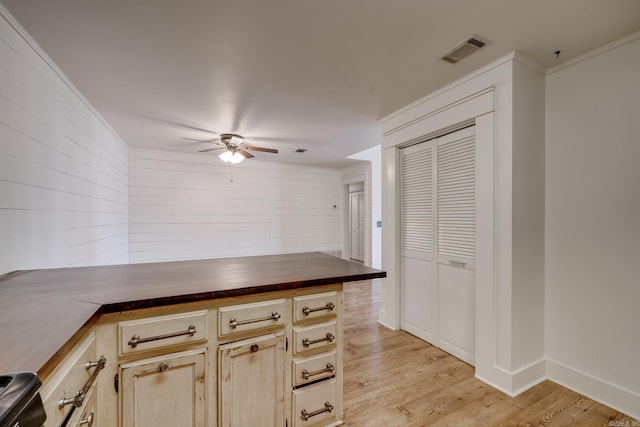 1005 S German Ln, Conway, AR 72034 - kitchen with a ceiling fan, a peninsula, light wood-style floors, wood counters, and ornamental molding