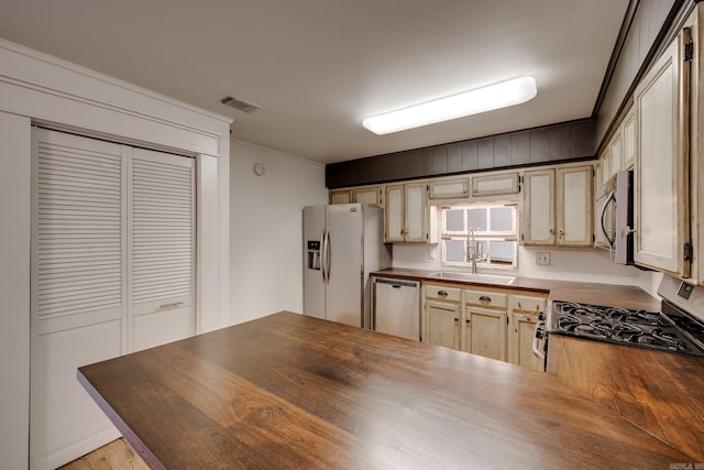 1005 S German Ln, Conway, AR 72034 - kitchen featuring wood counters, appliances with stainless steel finishes, crown molding, light wood-style floors, and a peninsula