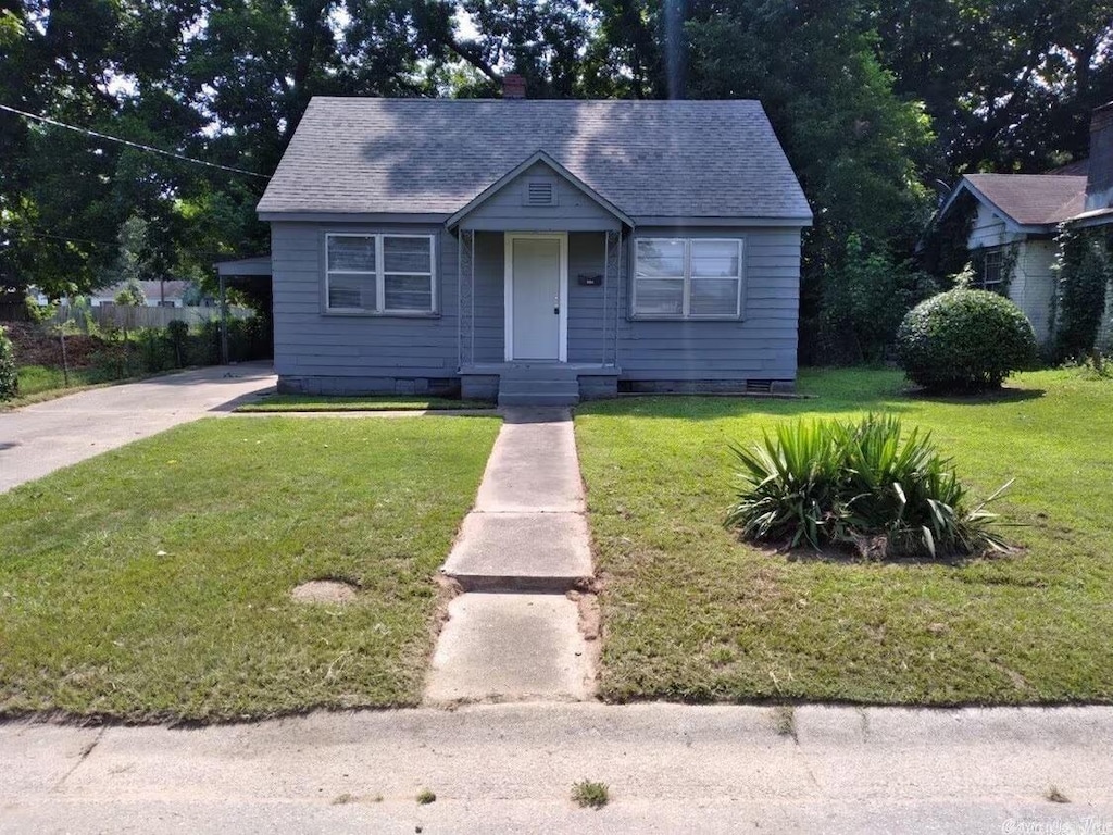 bungalow with a chimney, a front yard, a shingled roof, and crawl space