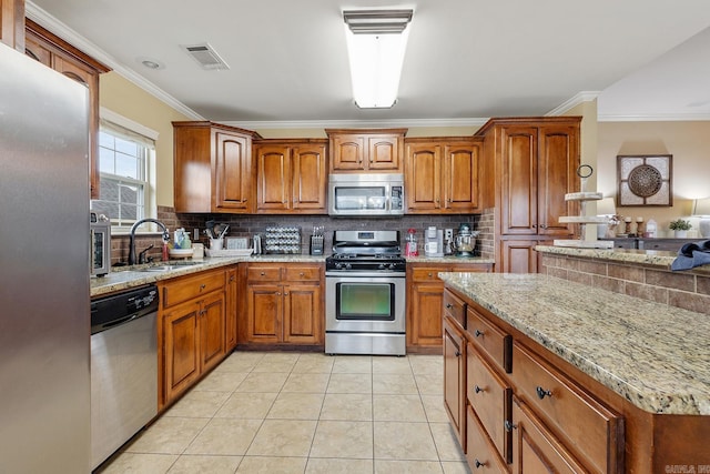 2104 Magna Carta Ln, Bryant, AR 72022 - kitchen with stainless steel appliances, brown cabinets, crown molding, and tasteful backsplash