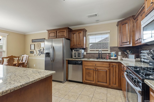 2104 Magna Carta Ln, Bryant, AR 72022 - kitchen featuring appliances with stainless steel finishes, crown molding, plenty of natural light, light tile patterned floors, and backsplash