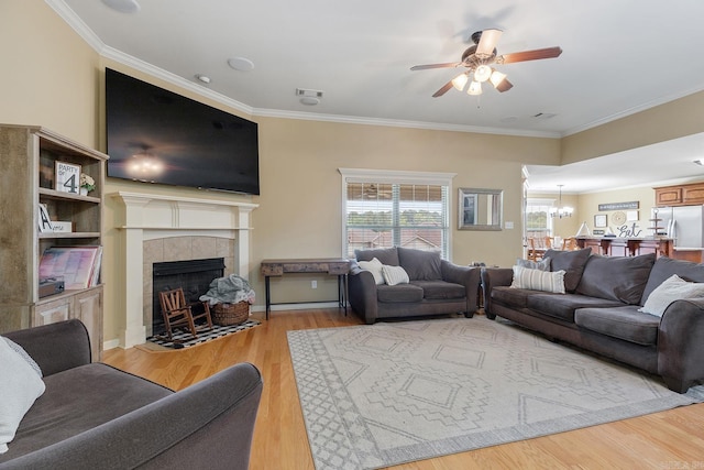 2104 Magna Carta Ln, Bryant, AR 72022 - living room with ceiling fan, a chandelier, wood finished floors, crown molding, and a tile fireplace