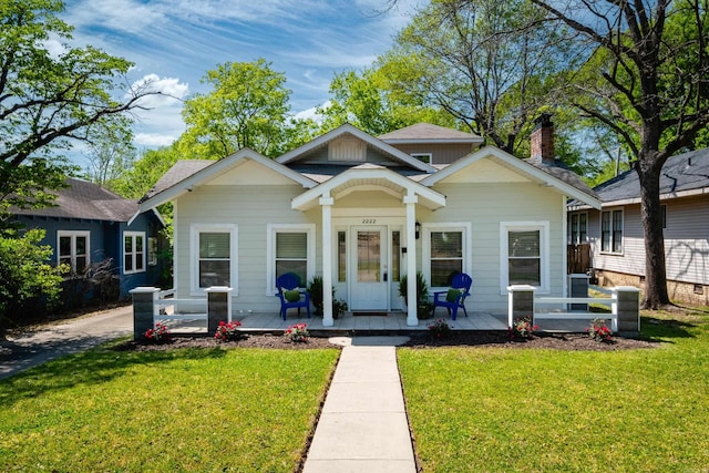 2222 N University, Little Rock, AR 72207 - bungalow with a porch, a front yard, a chimney, and a shingled roof