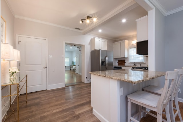 2222 N University, Little Rock, AR 72207 - kitchen featuring stainless steel refrigerator with ice dispenser, dark wood-style floors, light stone counters, white cabinets, and ornamental molding