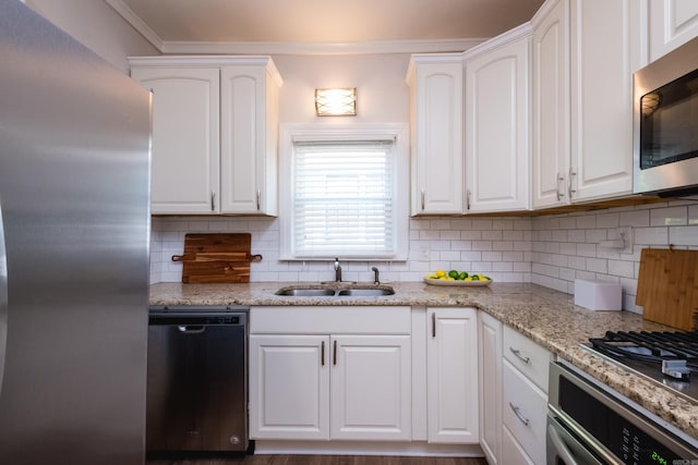 2222 N University, Little Rock, AR 72207 - kitchen featuring appliances with stainless steel finishes, white cabinetry, decorative backsplash, and crown molding