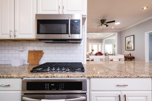 2222 N University, Little Rock, AR 72207 - kitchen featuring stainless steel appliances, ornamental molding, white cabinets, decorative backsplash, and ceiling fan