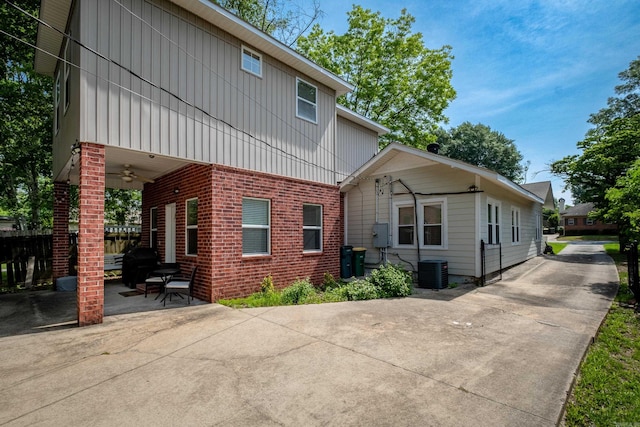 2222 N University, Little Rock, AR 72207 - rear view of property with board and batten siding, brick siding, a patio area, a ceiling fan, and driveway