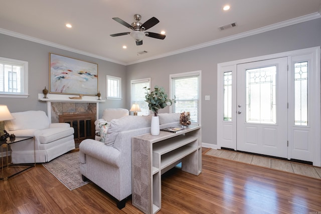 2222 N University, Little Rock, AR 72207 - living room featuring wood finished floors, ceiling fan, crown molding, a tile fireplace, and recessed lighting