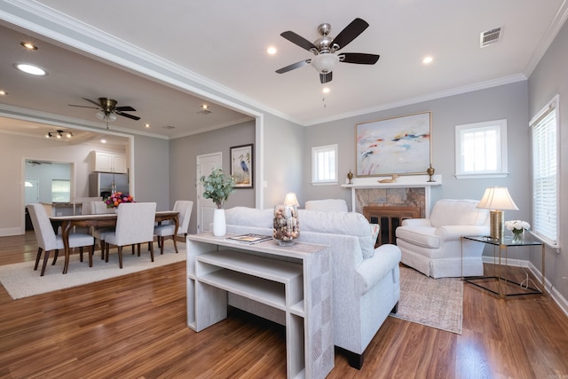 2222 N University, Little Rock, AR 72207 - living room featuring ceiling fan, wood finished floors, ornamental molding, a tile fireplace, and recessed lighting
