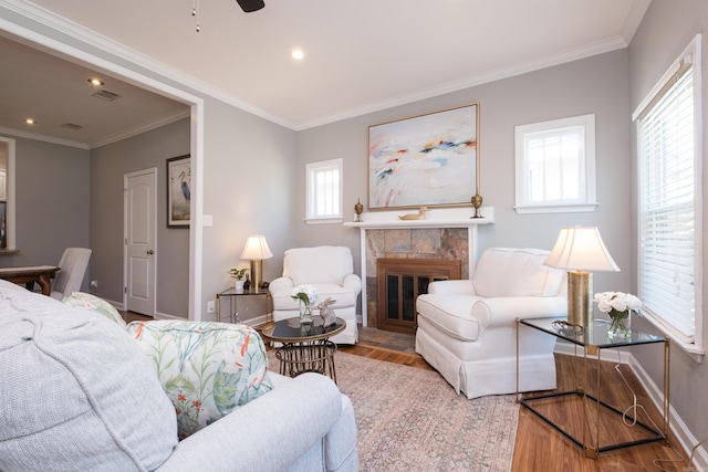 2222 N University, Little Rock, AR 72207 - living area featuring wood finished floors, plenty of natural light, a tiled fireplace, a ceiling fan, and crown molding