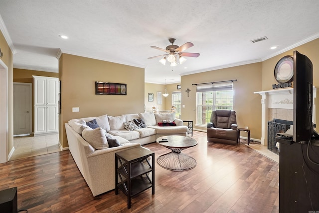 1700 Hosta, Conway, AR 72034 - living area featuring crown molding, a ceiling fan, wood finished floors, a tile fireplace, and recessed lighting