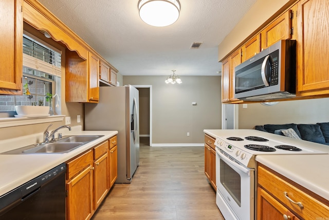 1410 Pyramid Dr, Conway, AR 72032 - kitchen featuring stainless steel appliances, light wood-type flooring, light countertops, brown cabinets, and a textured ceiling