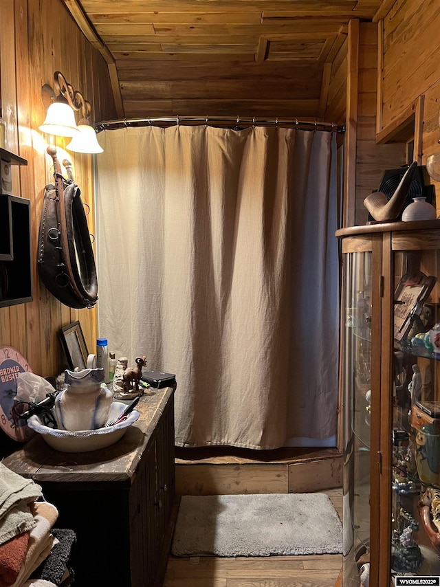 bathroom with wooden ceiling, wood walls, and hardwood / wood-style flooring