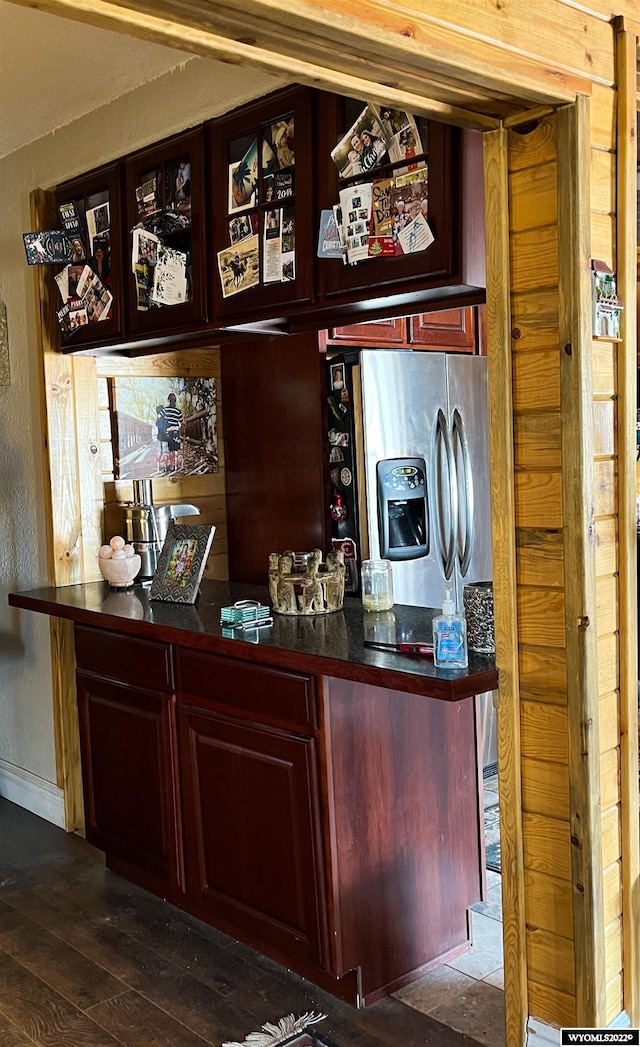 bar featuring dark hardwood / wood-style flooring and stainless steel refrigerator with ice dispenser