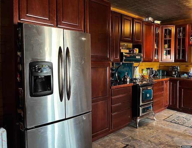 kitchen with appliances with stainless steel finishes, tile floors, and tasteful backsplash