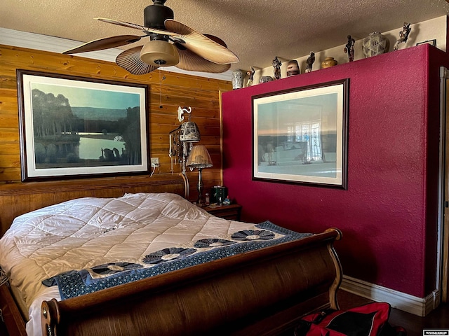 bedroom featuring ceiling fan, a textured ceiling, and wooden walls