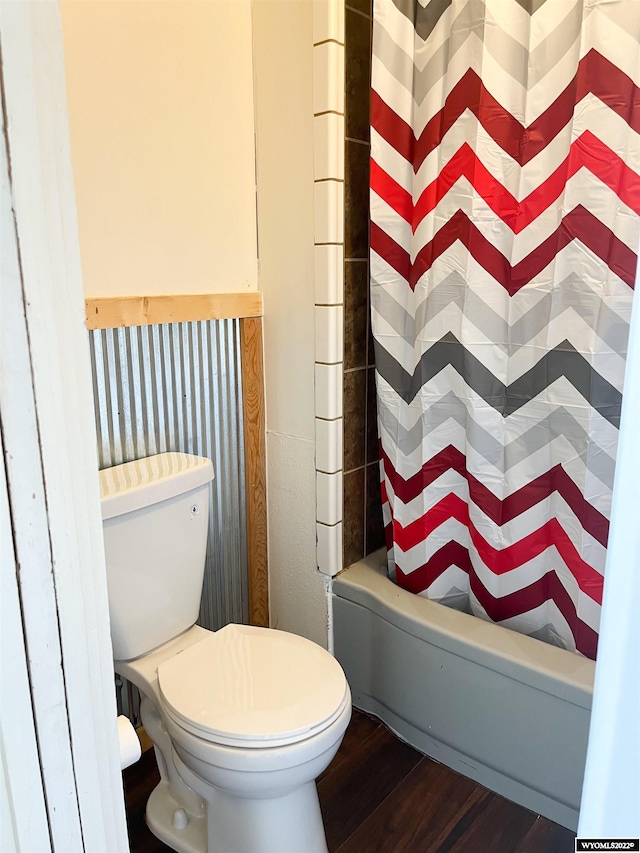 bathroom featuring shower / bath combo with shower curtain, toilet, and hardwood / wood-style flooring