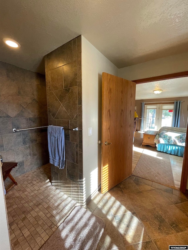 interior space with a textured ceiling, tile floors, and tile walls