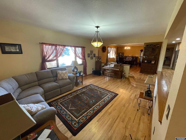 living room featuring light wood-type flooring and a textured ceiling