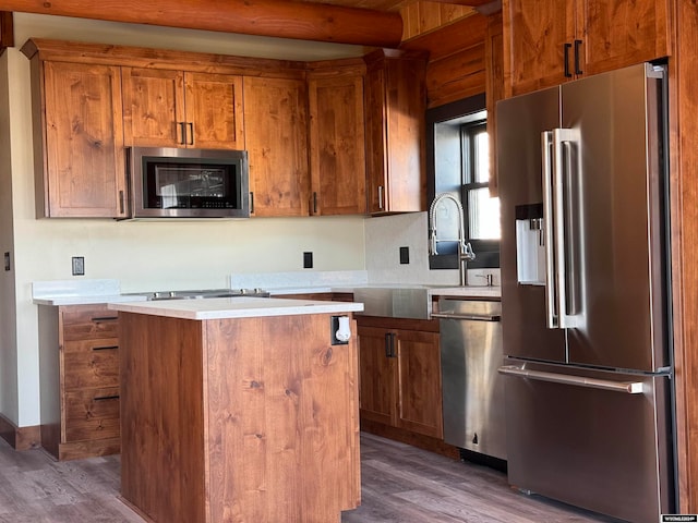 kitchen with appliances with stainless steel finishes, a center island, and dark hardwood / wood-style floors