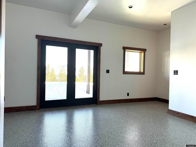 spare room with beamed ceiling and french doors