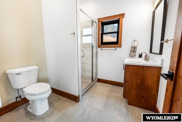 bathroom featuring toilet, vanity, and a shower with shower door