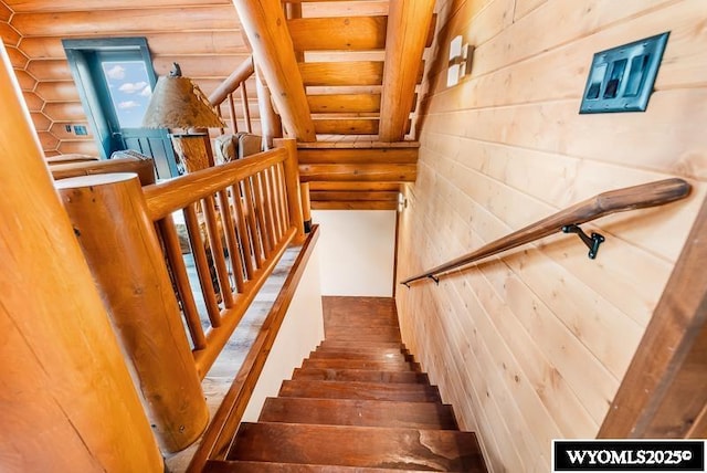 stairs featuring hardwood / wood-style floors and log walls