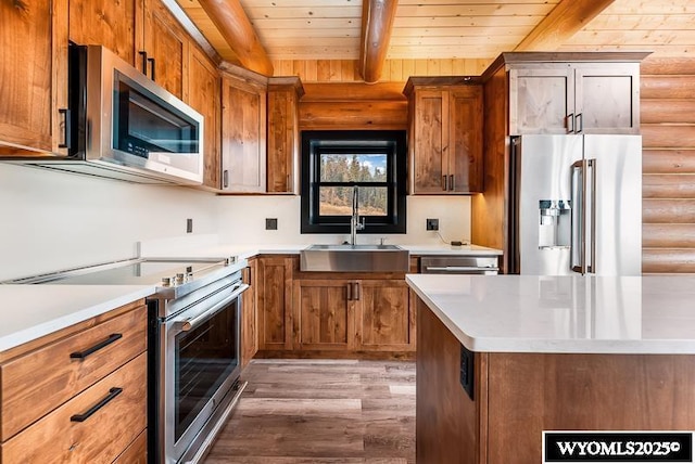 kitchen with beamed ceiling, sink, rustic walls, wood ceiling, and stainless steel appliances