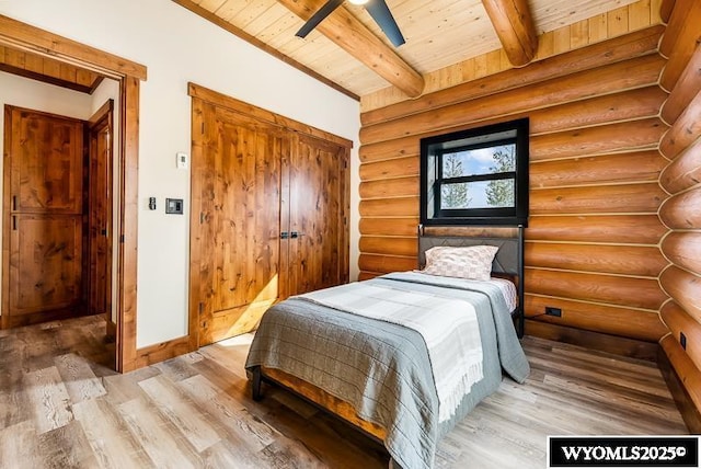 bedroom with wood ceiling, log walls, beam ceiling, and hardwood / wood-style floors