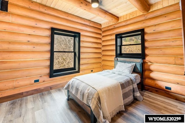 bedroom with hardwood / wood-style flooring, wood ceiling, beam ceiling, and log walls