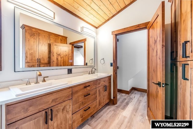 bathroom with wood ceiling, vaulted ceiling, ornamental molding, vanity, and hardwood / wood-style floors