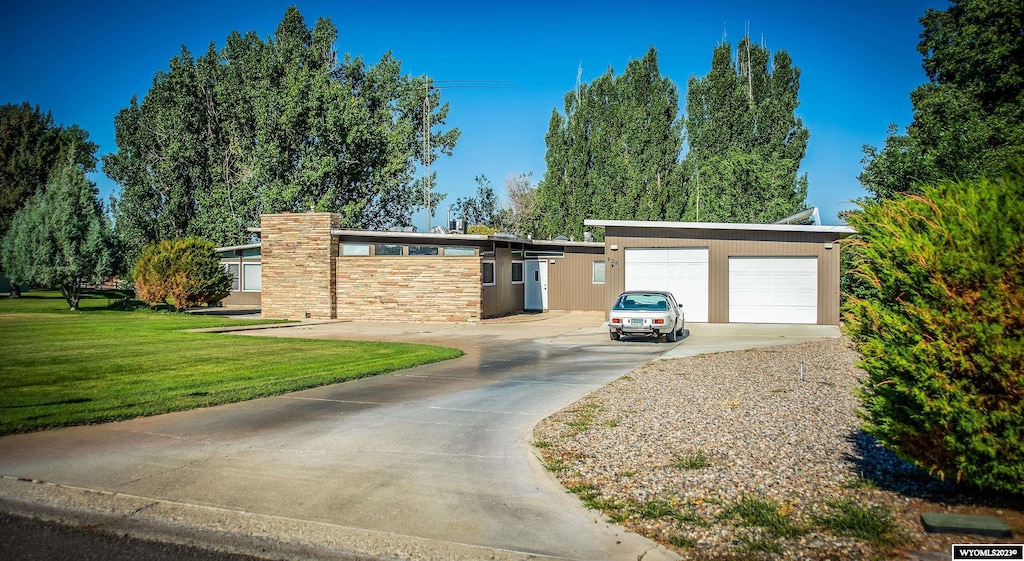 single story home featuring a front lawn, a garage, and a carport