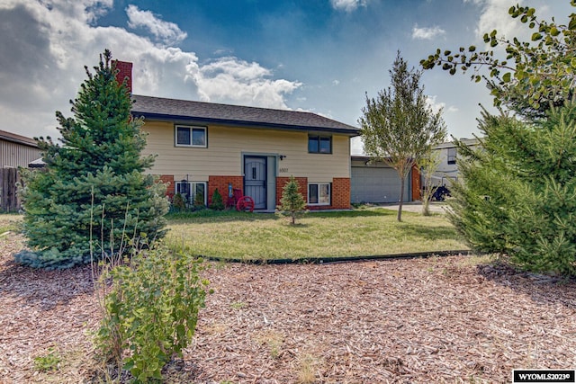 back of property featuring a lawn and a garage