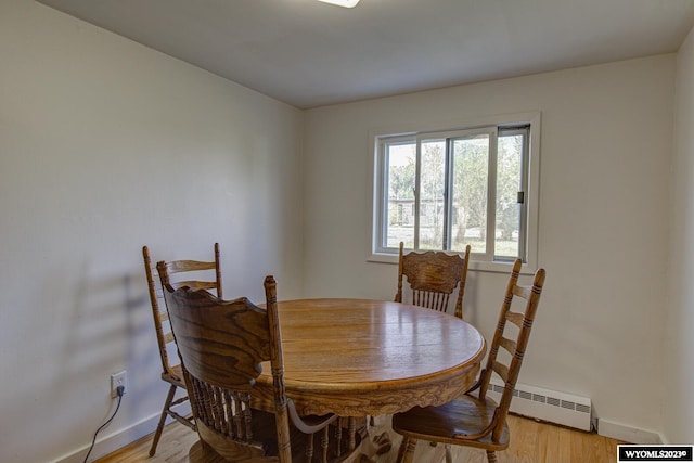 dining space featuring a baseboard radiator and light hardwood / wood-style floors