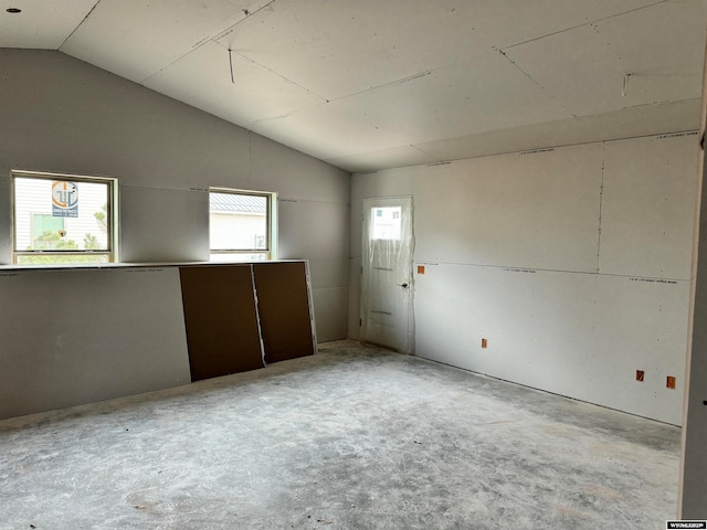 unfurnished room featuring lofted ceiling