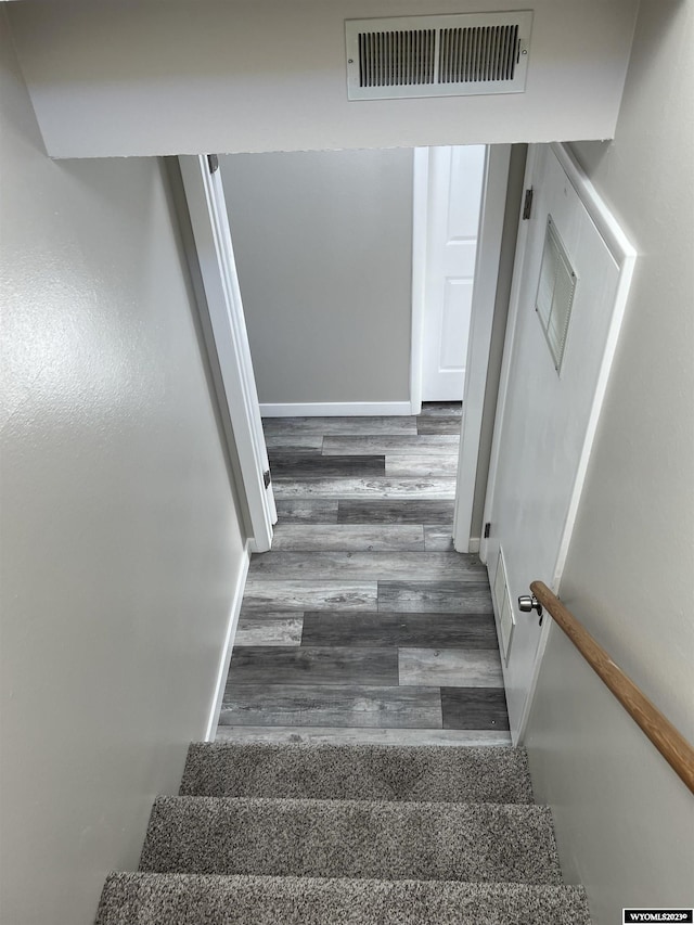 staircase with hardwood / wood-style flooring