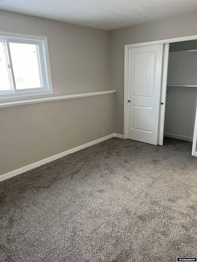 unfurnished bedroom featuring carpet flooring and a closet