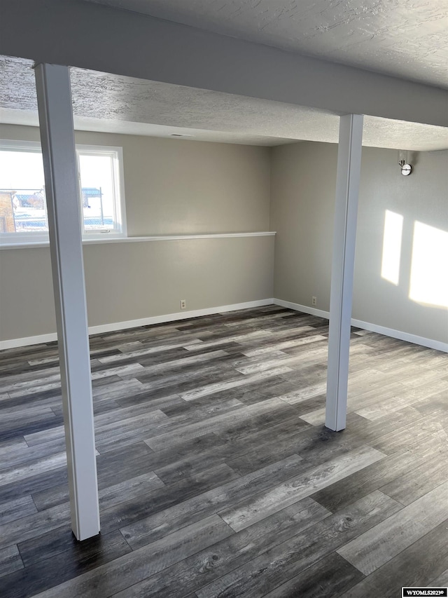 basement featuring dark hardwood / wood-style flooring and a textured ceiling