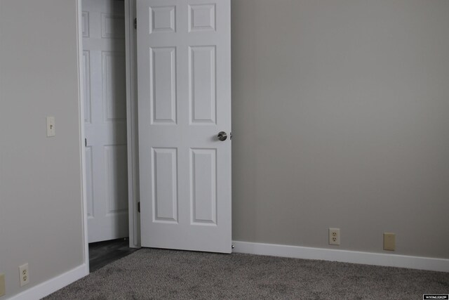 unfurnished bedroom featuring dark carpet