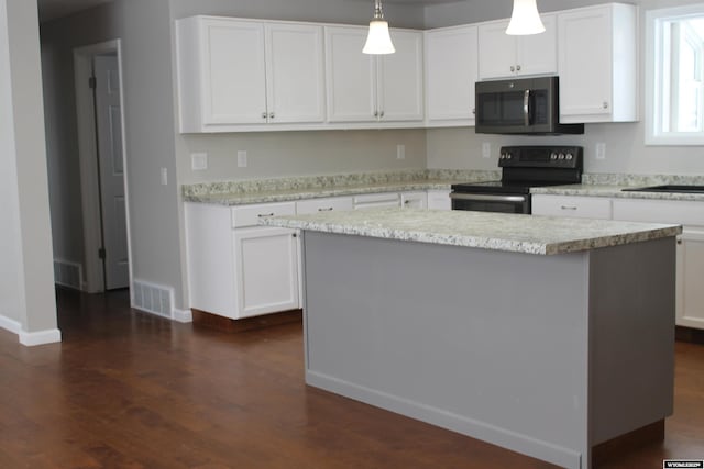 kitchen with black electric range, white cabinetry, hanging light fixtures, and a kitchen island