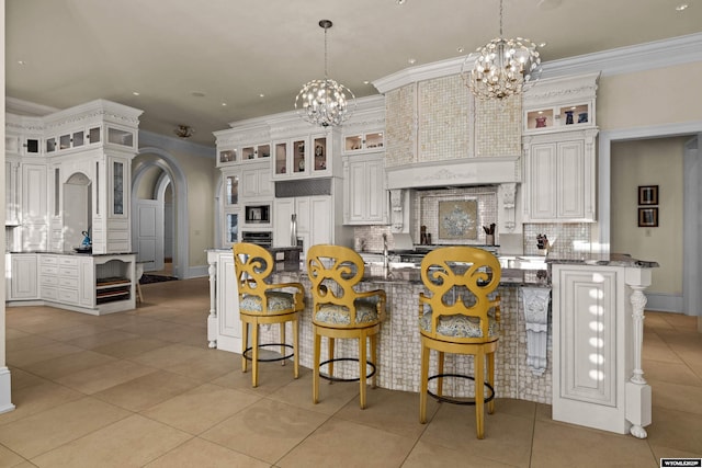 kitchen with pendant lighting, light tile patterned floors, crown molding, and decorative backsplash